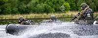 Soldaten fahren mit hoher Geschwindigkeit in einem Schlauboot auf einem Fluss