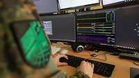 Ein Soldat sitzt an einem Computer und arbeitet.