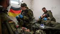 Mehrere Sanitäter behandeln liegende Verwundete in einem beleuchteten Keller.