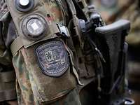 Ein Soldat steht draußen mit seiner Waffe und trägt eine Sensorausstattung für die Duellsimulation.