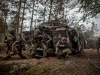 Viele Soldaten sitzen aus mehreren Schützenpanzern Puma auf einem Waldweg ab.