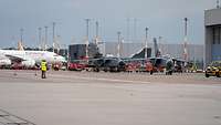 Zwei Kampfflugzeuge Tornado fahren auf dem Hamburg Airport. Dahinten ein ziviles Passagierflugzeug.