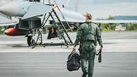 Pilot mit Ausrüstung geht auf bewaffneten Eurofighter zu