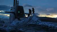 Zwei Soldaten stehen auf einem U-Boot im Meer