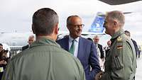 Friedrich Merz lächelt einen General der Luftwaffe in Fliegerkombi an. Im Hintergrund steht ein Flugzeug der Luftwaffe. 