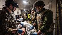 Soldaten versorgen bei einer Übung einen Soldaten, der einen Verwundeten spielt, in einem Schutzraum.