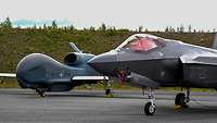 RQ-4D Phoenix neben einer F-35 auf dem Luftwaffenstützpunkt Pirkkala