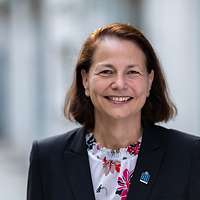 Eine strahlende Frau in Blazer