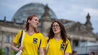 zwei Mädchen in gelben Shirts vor dem Bundestag