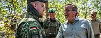 Boris Pistorius gibt einem Bundeswehrsoldaten auf dem Übungsplatz Pabradė die Hand.