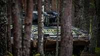 Ein Schützenpanzer im dichten Wald.