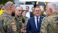 Boris Pistorius und Carsten Breuer sprechen beim Veteranentag mit zwei Soldaten.