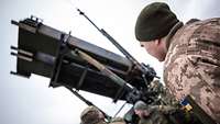 Ein ukrainischer Soldat steht vor dem Flugabwehrsystem Patriot.