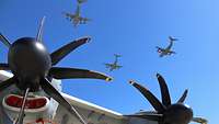 Vom Boden sieht man drei in Formation fliegende A400M in der Luft.