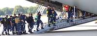 Einsatzkräfte des THW steigen über die Heckrampe an Board eins A400M der Luftwaffe.