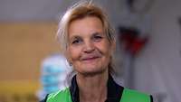 Portrait einer Frau mit grüner Weste, sie blickt in die Kamera