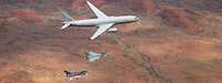 Zwei deutsche Eurofighter und ein Flugzeug in der Luft.