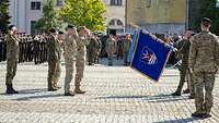 Soldaten salutieren bei der Übergabe einer Truppenfahne auf dem Appellplatz.