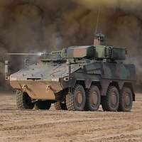 Ein Radpanzer steht im Gelände. Im Hintergrund ist eine Staubwolke zu sehen.