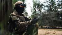 Ein Soldat mit FPV-Brille und Controller steuert eine Drohne.
