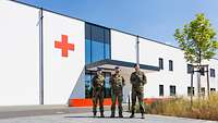 Drei Soldaten vor einem großen weißen Gebäude mit rotem Kreuz an der Frontseite. 