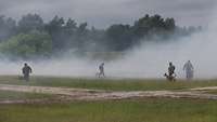 Soldaten mit Hunden im Nebel auf einer Wiese