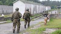 Ein Soldat mit Hund vor einer Mauer