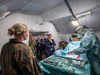 Boris Pistorius steht in einem Operationszelt und schaut einer Operation zu.