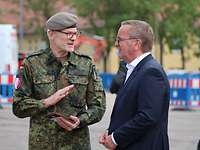 Boris Pistorius im Gespräch mit einem Soldaten, beide stehen sich gegeüber.