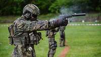 Soldaten schießen in Weste und Helm mit der Pistole P12 