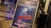 Ein Schild mit der Aufschrift „Auf Wiedersehen“ und „21. Mai 2027“.