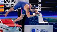Ein Schwimmer springt nach dem Start ins Wasser