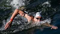 Mann schwimmt im Wasser. 