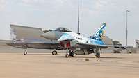 An F-35 and a specially wrapped Eurofighter together on an airfield.