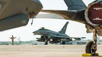 An Australian soldier marshalling a German Eurofighter.
