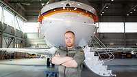 Porträt eines Fluggerätmechanikers vor einem Flugzeug
