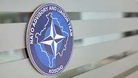 Ein blaues Wappen mit der Aufschrift „Nato Advisory and Liaison Team Kosovo“
