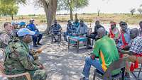 Blauhelmsoldaten sprechen mit Einwohnern eines Dorfes im Südsudan