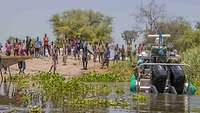 Ein Motorboot mit UN-Soldaten legt an einem Flussufer in Afrika an