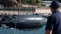 Eine Unterwasserdrohne die an zwei Seilen hängt