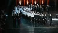 Marinesoldaten vom Marinechor laufen in Formation bei einer Veranstaltung.