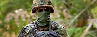 Ein vermummter Soldat mit Gewehr im Porträt
