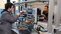 Zwei Menschen arbeiten an elektronischen Teilen.