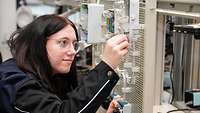 Eine Frau arbeitet an elektronischen Teilen.