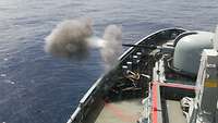 Eine Kanone auf dem Schiff gibt einen Schuss ab
