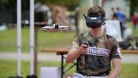 Ein junger Mann mit VR-Brille steuert eine Drohne.
