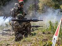 Zwei Soldaten schießen mit Panzerfäusten, Rauch strömt am hinteren Ende heraus.