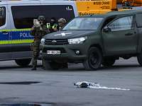 Soldaten und die Bundespolizei stehen gedeckt hinter einem Fahrzeug