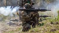 Zwei Soldaten schießen mit Panzerfäusten, Rauch strömt am hinteren Ende heraus.