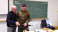 Ein Zivilist und ein Soldat mit einer Kleinwaffe